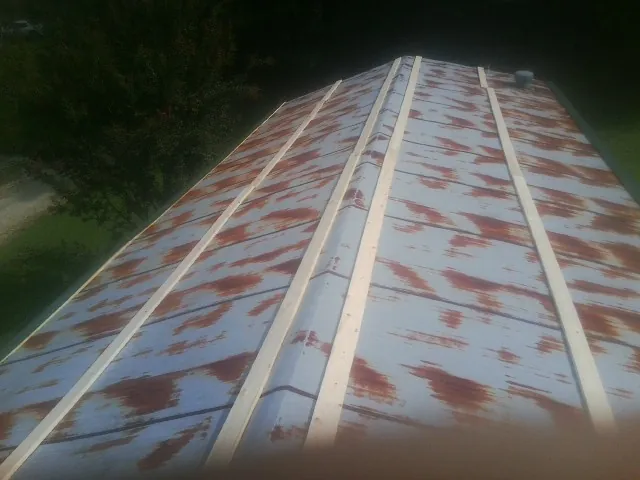 Rusted metal roof panels with new wood purlins before replacement — Storm Damage Roof Repair in Elm City by Roofing Brothers