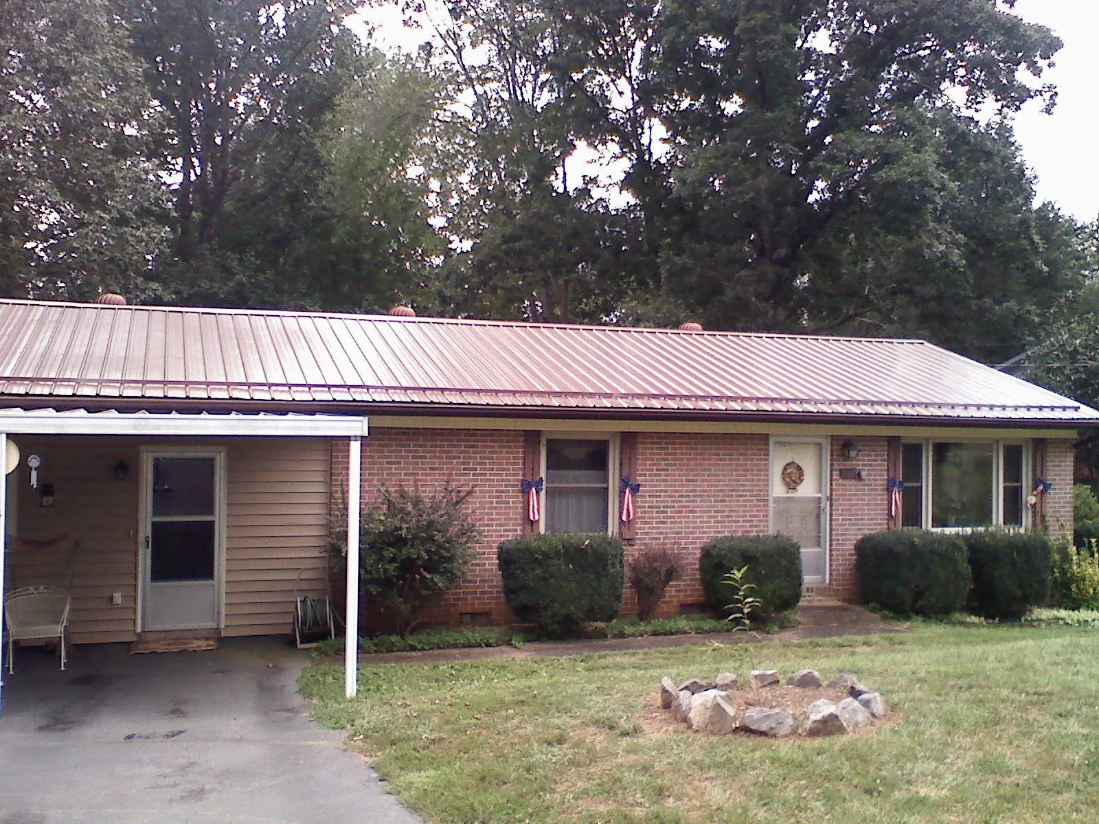 Bronze metal roof and carport on a brick ranch home — Roof Repair work by our crew in Elm City