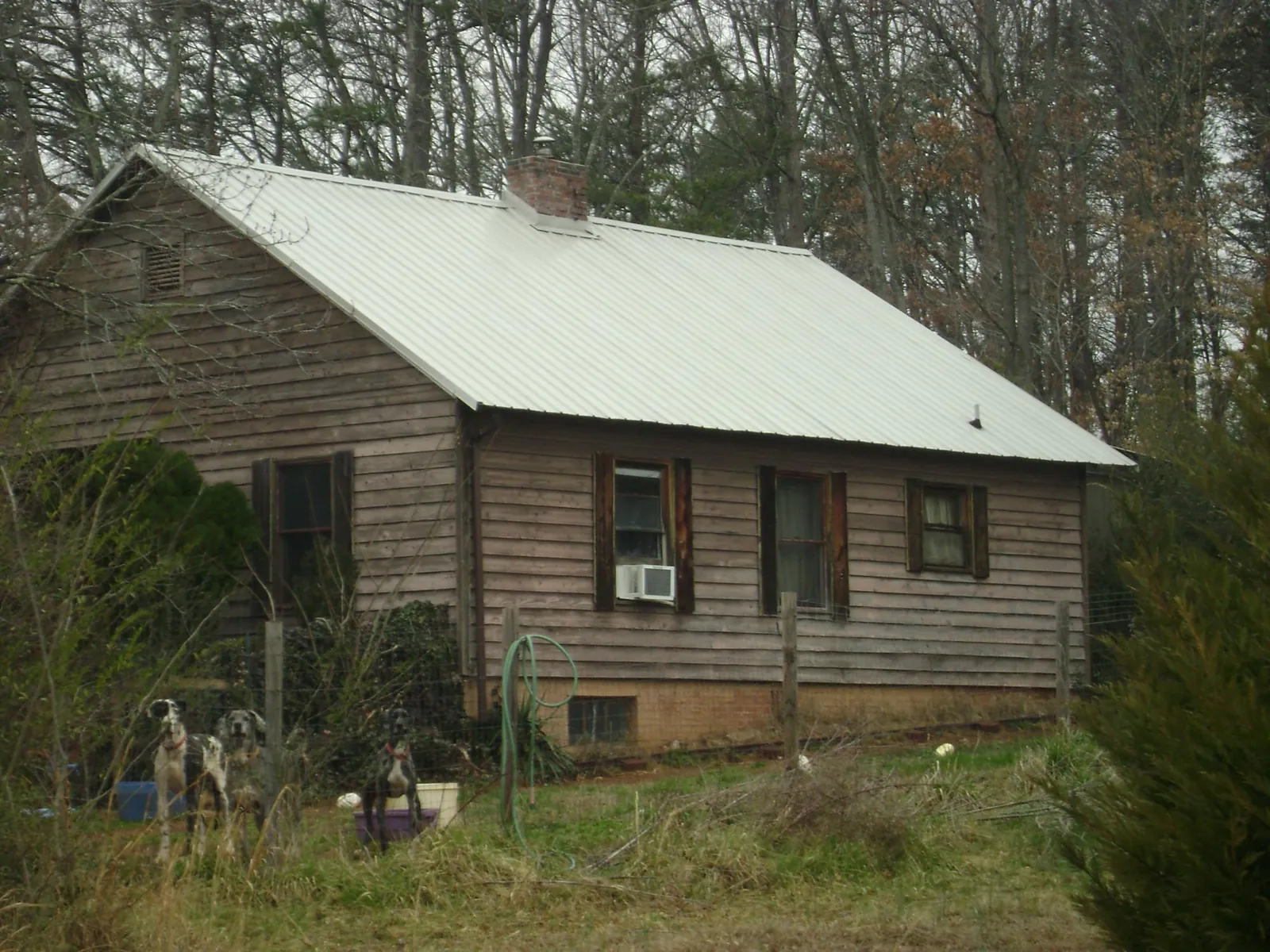 White metal roof on an old wood sided farmhouse, from a Metal Roof Installation job in Elm City